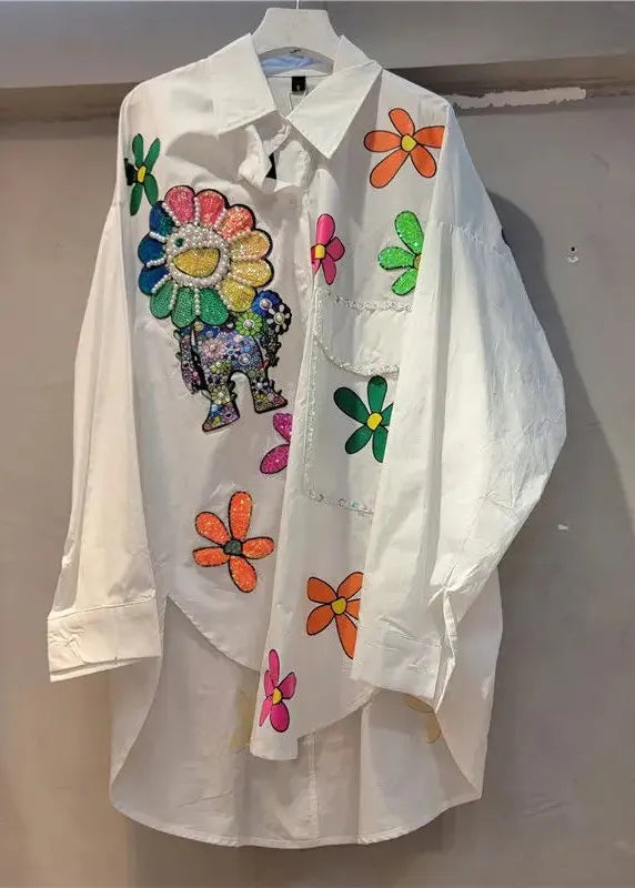 White shirt with colorful floral and animal designs on a plain background