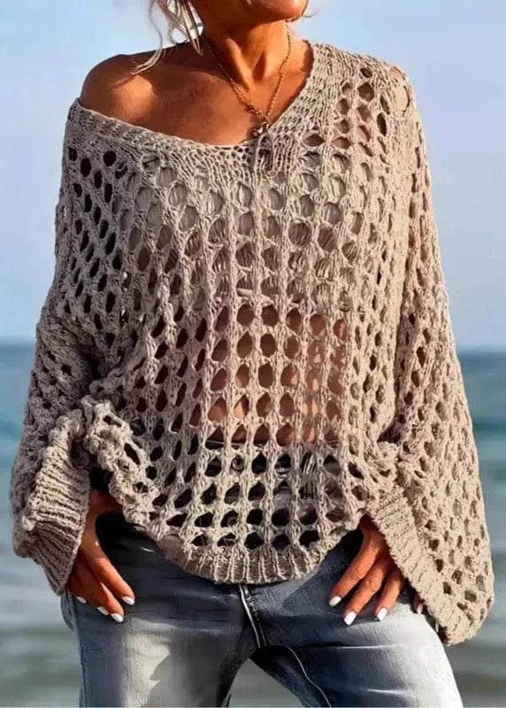 Person wearing a beige crochet sweater by the beach