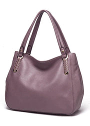 Purple handbag with gold accents on a white background
