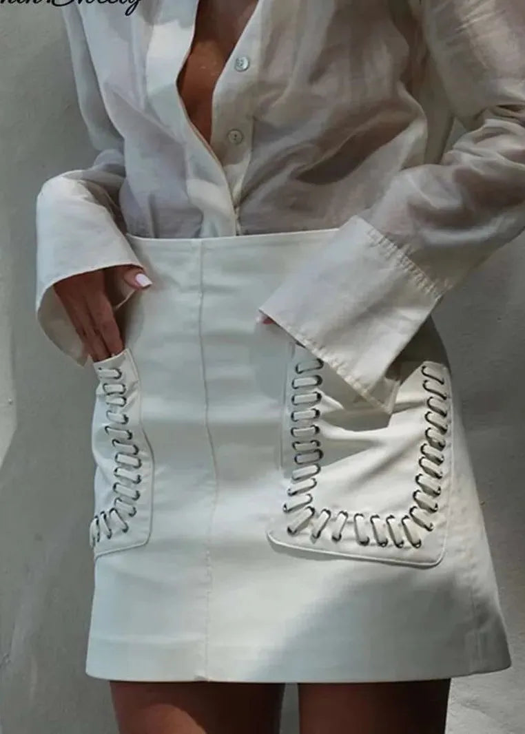 White lace-up skirt worn with a light-colored shirt against a neutral background