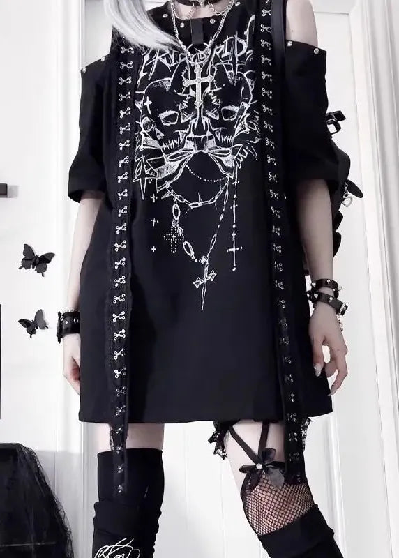 Person wearing a black outfit with white designs, standing in a room with decor elements.