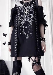 Person wearing a black outfit with white designs, standing in a room with decor elements.