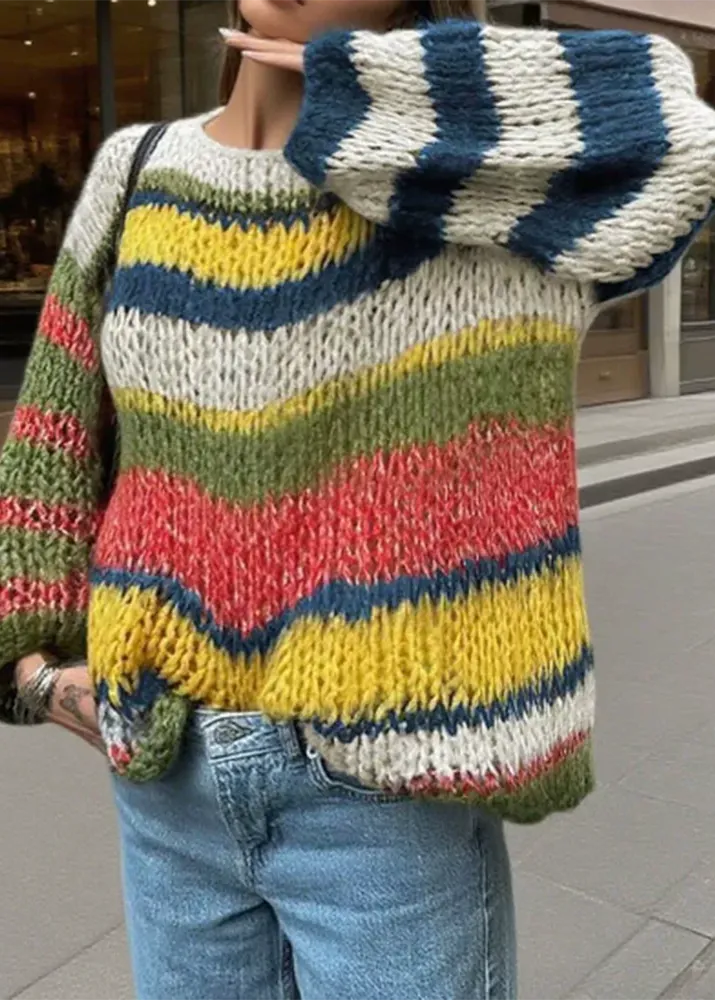 Person wearing a colorful striped sweater with a blurred background