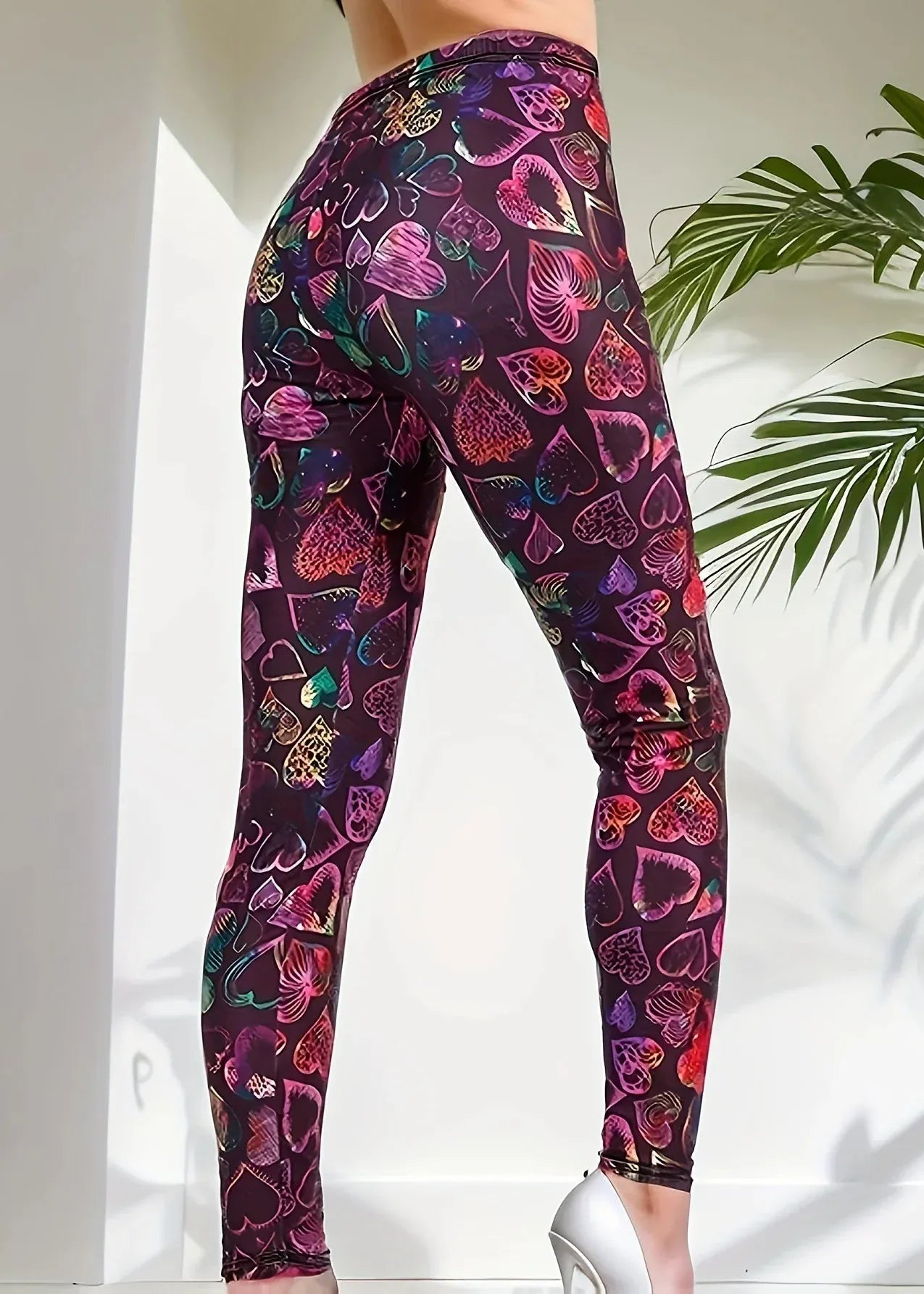Colorful heart-patterned leggings worn by a person on a white background