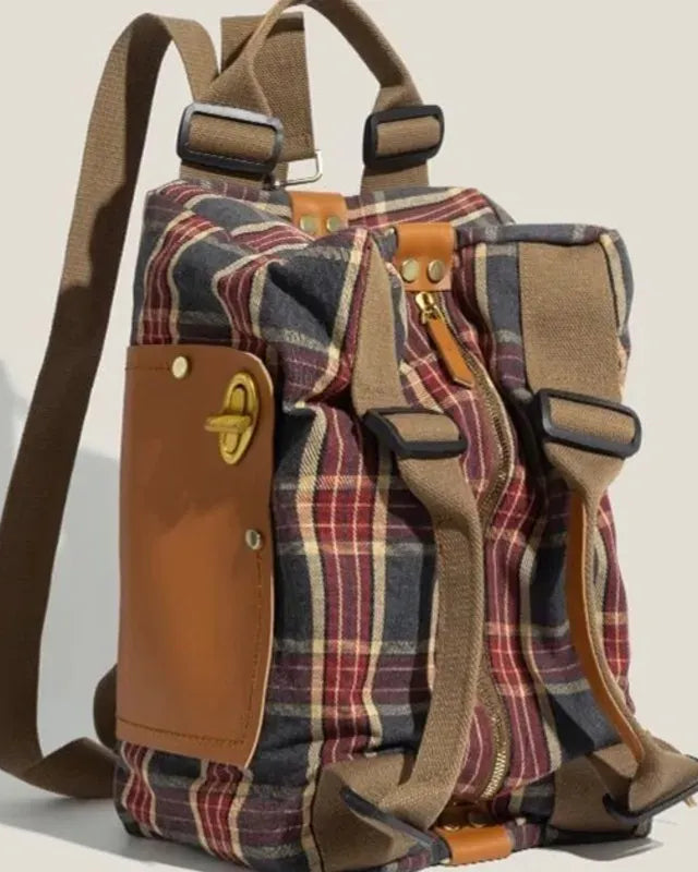 Plaid backpack with brown leather accents on a beige background