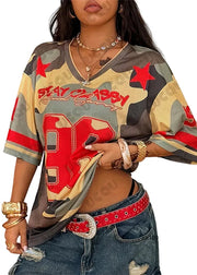 Person wearing a colorful graphic t-shirt with text and designs, standing against a neutral background.