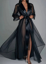 Black sheer dress with a deep neckline on a gray background