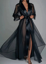 Black sheer dress with a deep neckline on a gray background