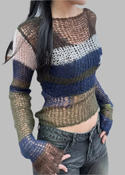 Person wearing a multicolored crochet sweater and jeans indoors.
