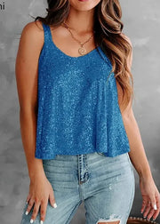 Woman wearing a blue sequin tank top and jeans against a gray background
