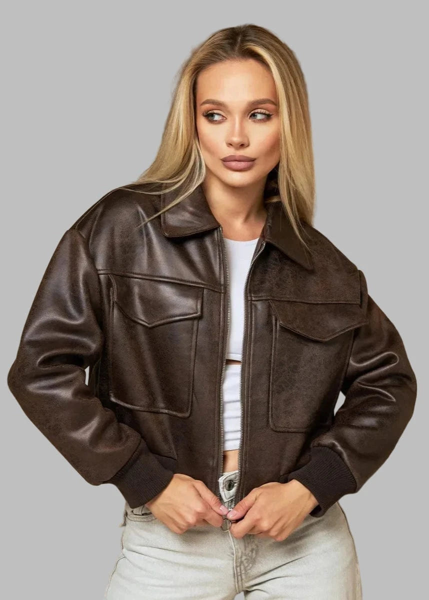 Woman wearing a brown leather jacket against a beige curtain background