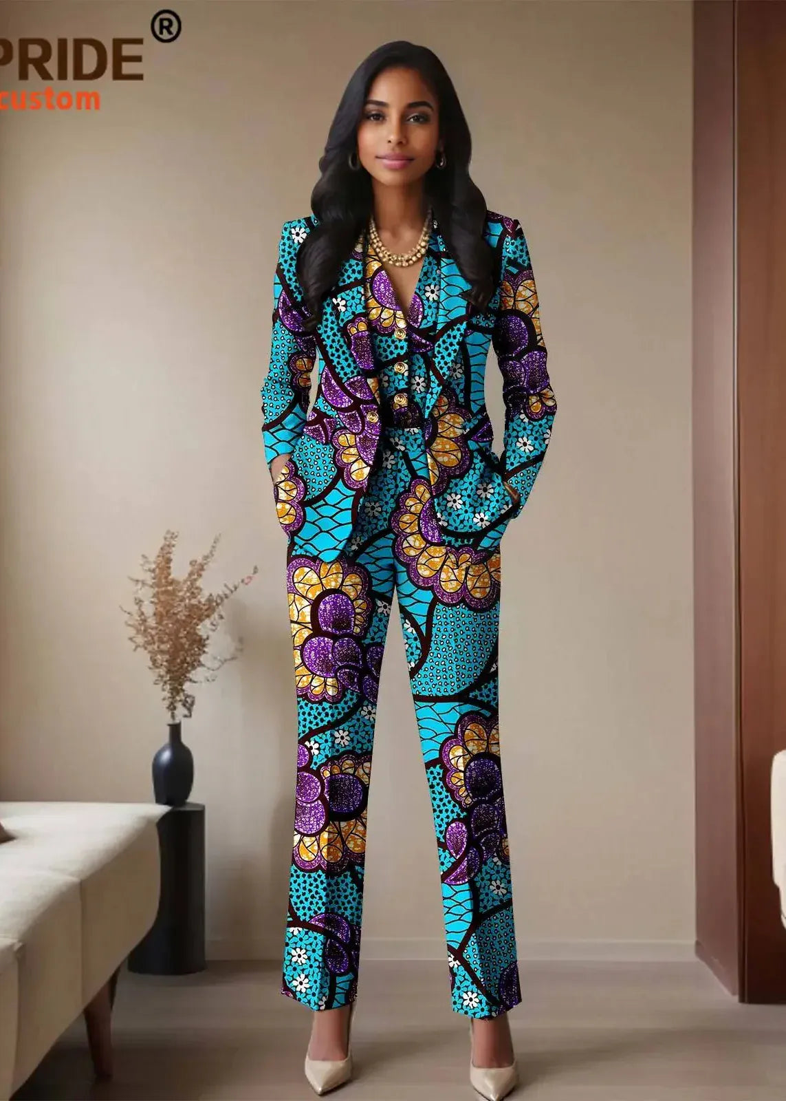 Woman wearing a colorful patterned jumpsuit in a room with a couch and vase.