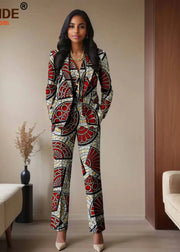 Woman wearing a patterned suit standing in a room with beige walls and a couch.