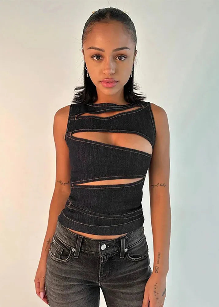 Woman wearing a black denim top with cut-out design against a plain background