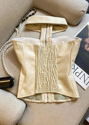 Beige textured handbag on a beige couch with a magazine underneath
