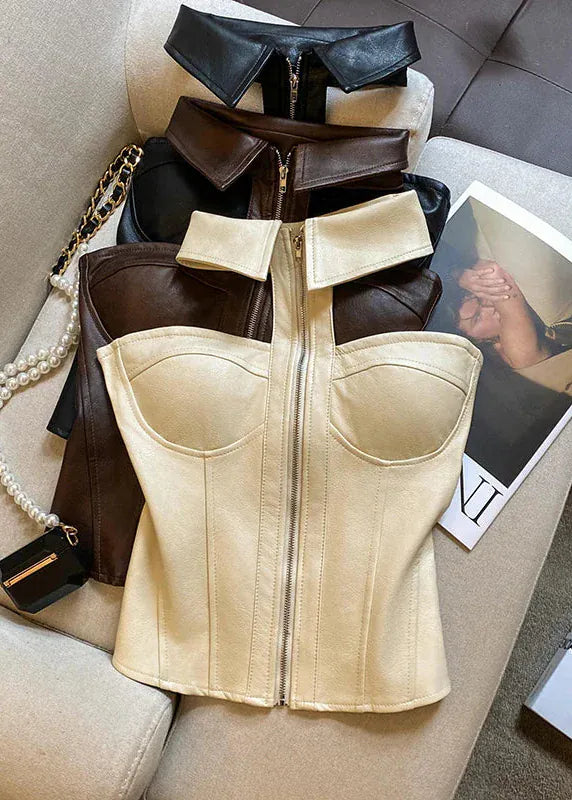 Beige corset on a beige cushion with a magazine and handbag in the background.