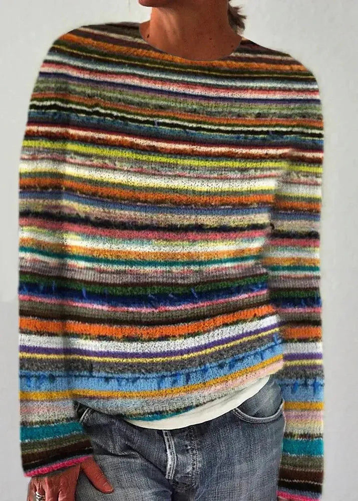 Multicolored striped sweater worn by a person on a plain background