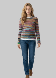 Woman wearing a colorful striped sweater and blue jeans on a white background with 'arvin' branding.