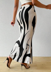 Person wearing a black and white patterned skirt on a plain background