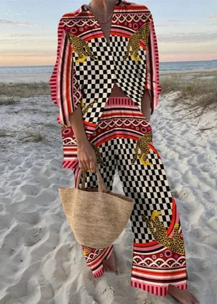 Person wearing a colorful outfit with a checkered pattern on a beach.