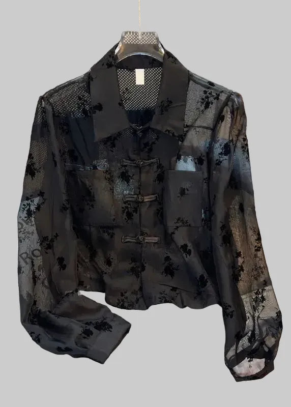 Black floral patterned shirt on a chair with a blurred background