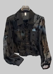 Black floral patterned shirt on a chair with a blurred background
