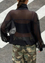 Person wearing a sheer black top and camouflage pants on a zebra crossing