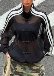 Person wearing a black outfit with sheer sleeves and camouflage pants on a crosswalk.