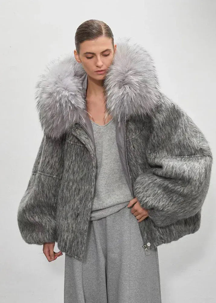 Woman wearing a gray fur coat against a white background