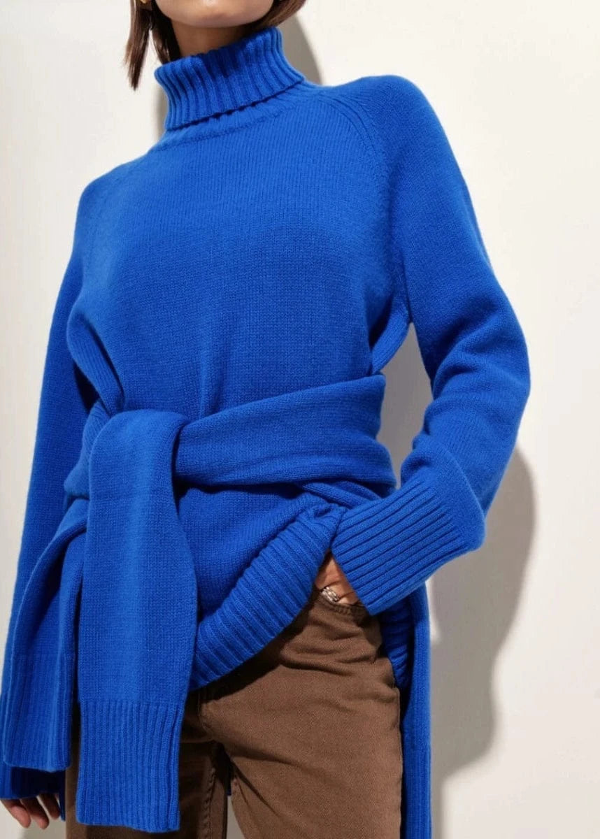 Blue turtleneck sweater worn by a person on a plain background