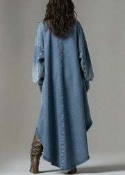 Person wearing a long denim coat with brown boots on a plain background