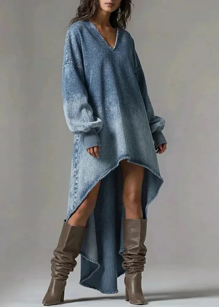 Woman wearing a long blue sweater and brown knee-high boots on a plain background