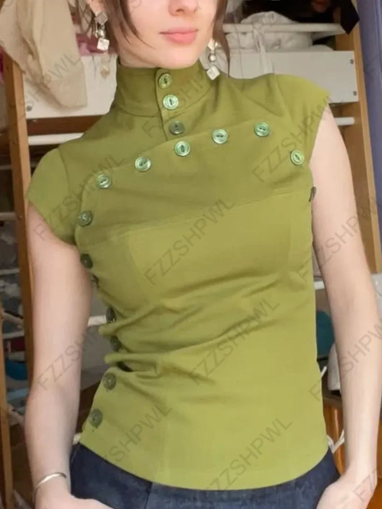 Person wearing a green sleeveless top with buttons, standing indoors.