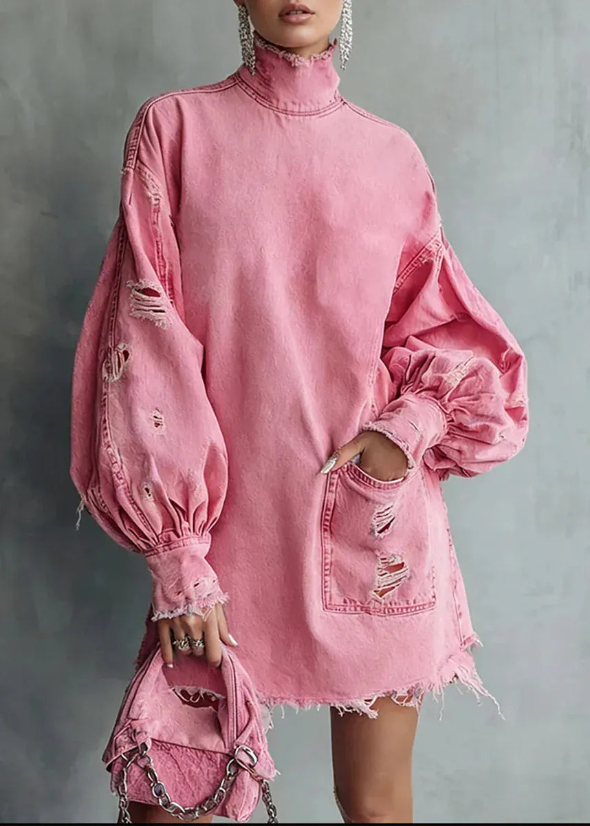 Pink denim dress with distressed details on a gray background