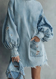 Denim dress with distressed details on a plain background