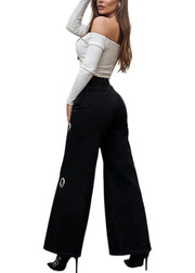 Woman wearing a white off-shoulder top and black wide-leg pants with button details on a white background