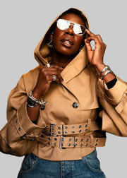 Person wearing a beige jacket and sunglasses indoors