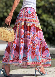 Person wearing a colorful patterned skirt holding a straw bag outdoors.