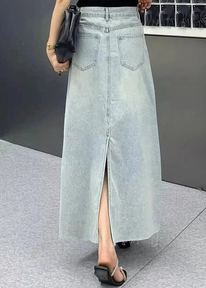 Long denim skirt with a front slit worn by a person on a neutral background