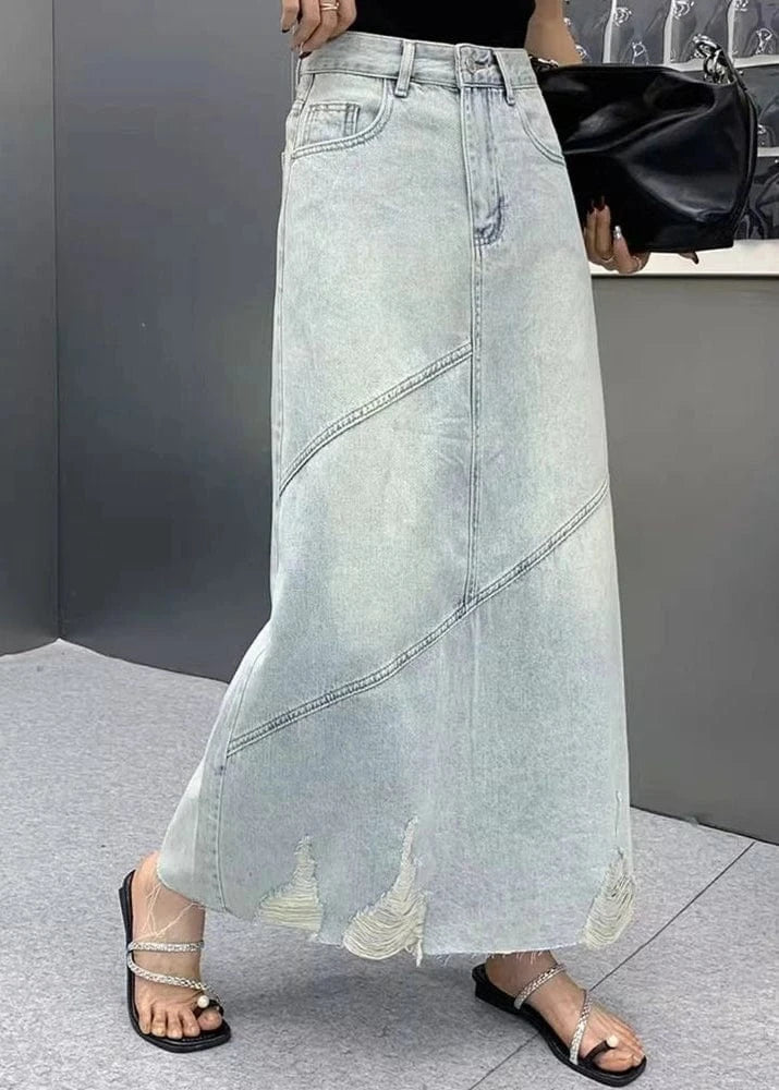 Person wearing a light blue denim skirt with a blurred background