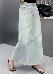 Person wearing a light blue denim skirt with a blurred background