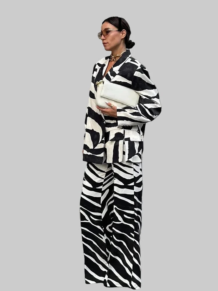 Person wearing a zebra print outfit with a white bag, standing outdoors with 'Trafza' branding.